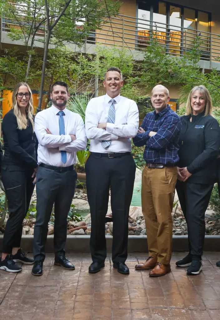 gen-mobile-3 Five smiling team members from Gentle Dentistry, three men and two women, standing outdoors